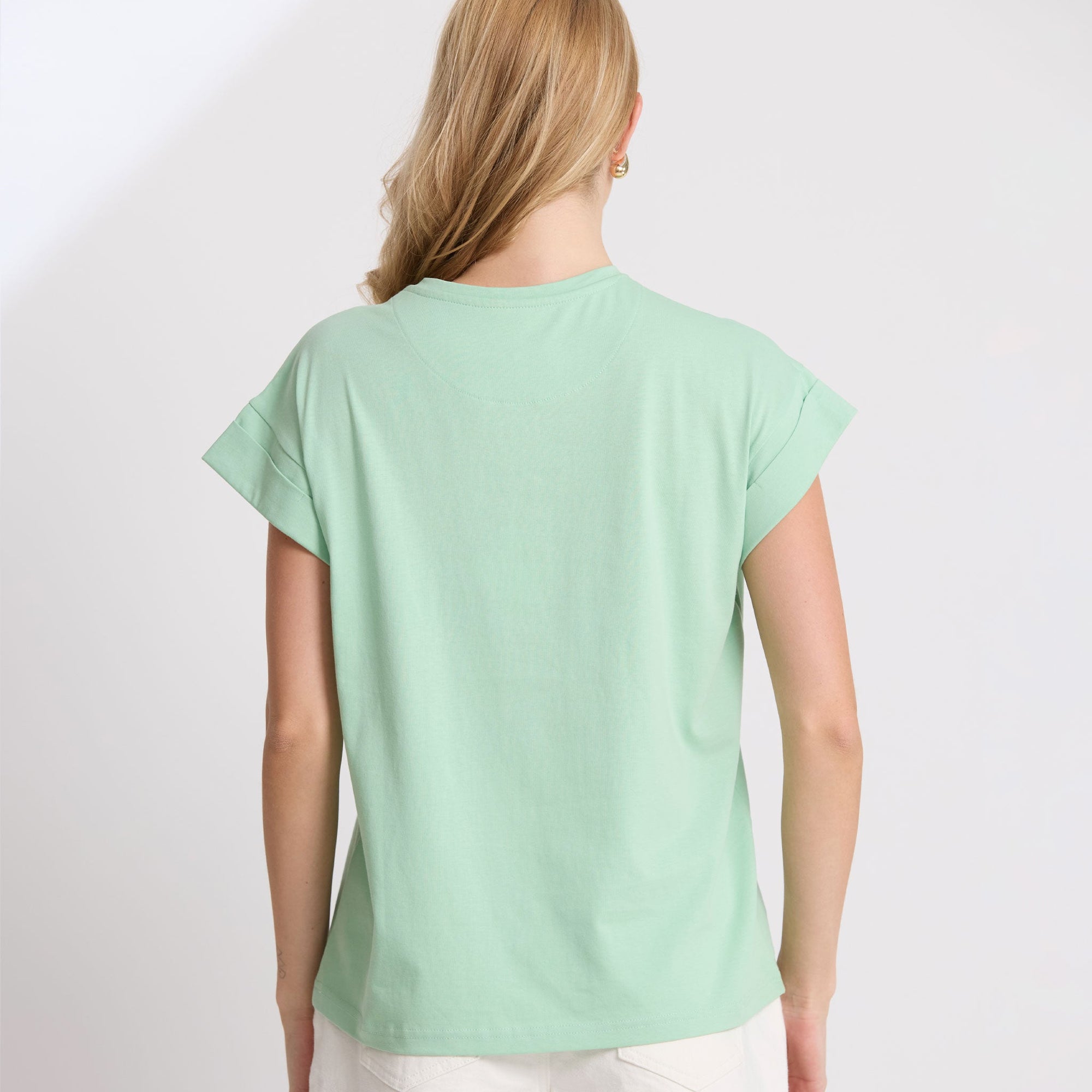 Woman wearing a light green t-shirt on a white background