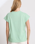 Woman wearing a light green t-shirt on a white background