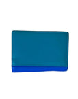 A two-tone leather wallet with a teal blue top flap and a vibrant royal blue bottom section, placed flat on a light brown wood grain surface.