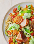 Salmon salad with vegetables and quinoa on a white plate