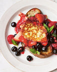 Plated dish with berry sauce and bread on a white plate