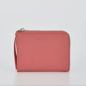 Pink wallet with a strap on a light gray background