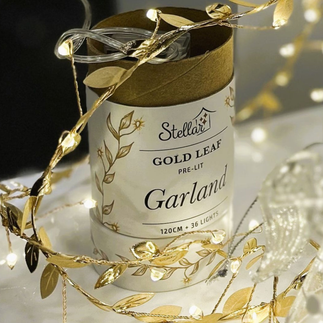 Stellar Gold Leaf Pre-Lit Garland packaging with gold leaf strands on a dark background