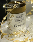 Stellar Gold Leaf Pre-Lit Garland packaging with gold leaf strands on a dark background