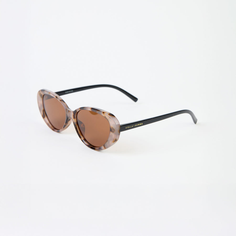 Sunglasses with tortoiseshell frame and brown lenses on a white background
