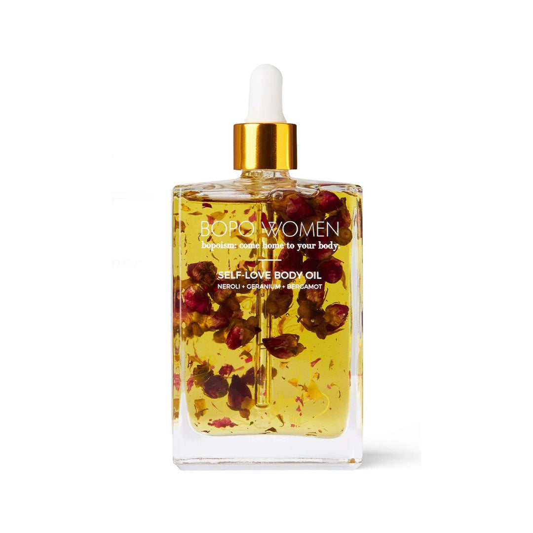 Bottle of self-love body oil with floral elements on a white background