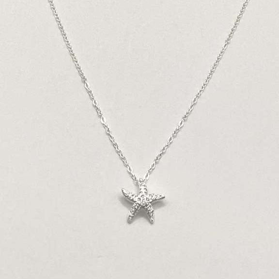 Star-shaped silver pendant necklace on a light gray background