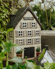 Miniature model of a hotel surrounded by greenery and white flowers
