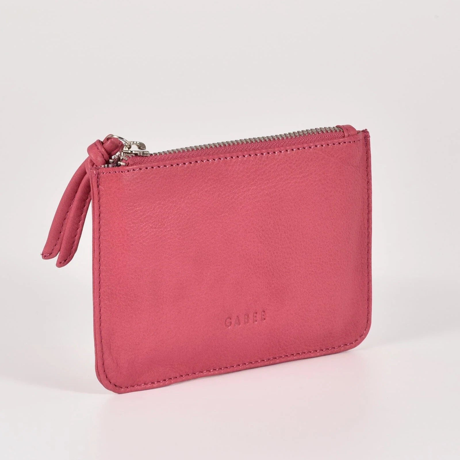 Pink wallet with a zipper on a light gray background